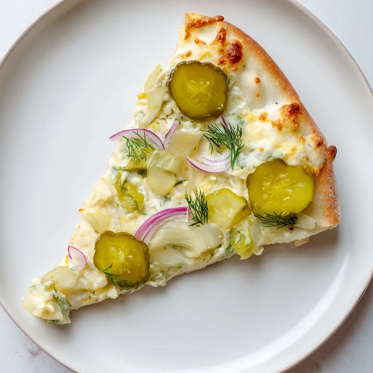 Delicious Pickle Pizza with creamy sauce, mozzarella, and crunchy dill toppings.  