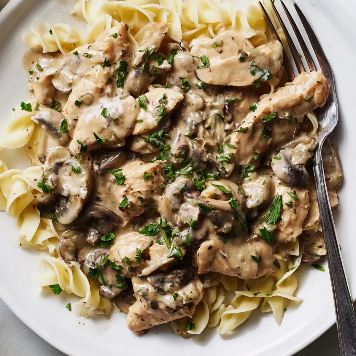 Creamy Chicken Stroganoff served over noodles with tender chicken and rich mushroom sauce.  