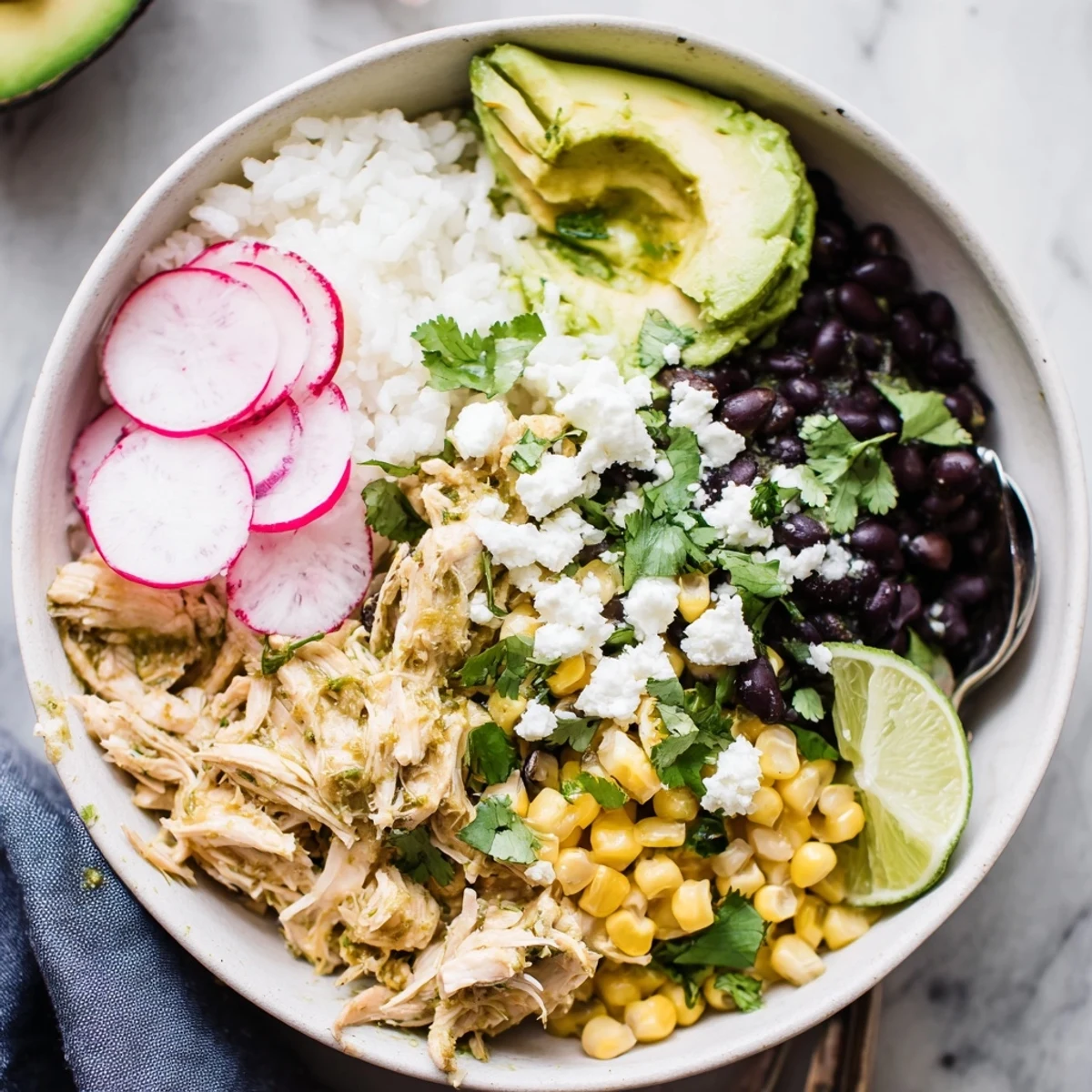 Vibrant green enchiladas rice bowl topped with tender chicken, fresh avocado, and cilantro.  