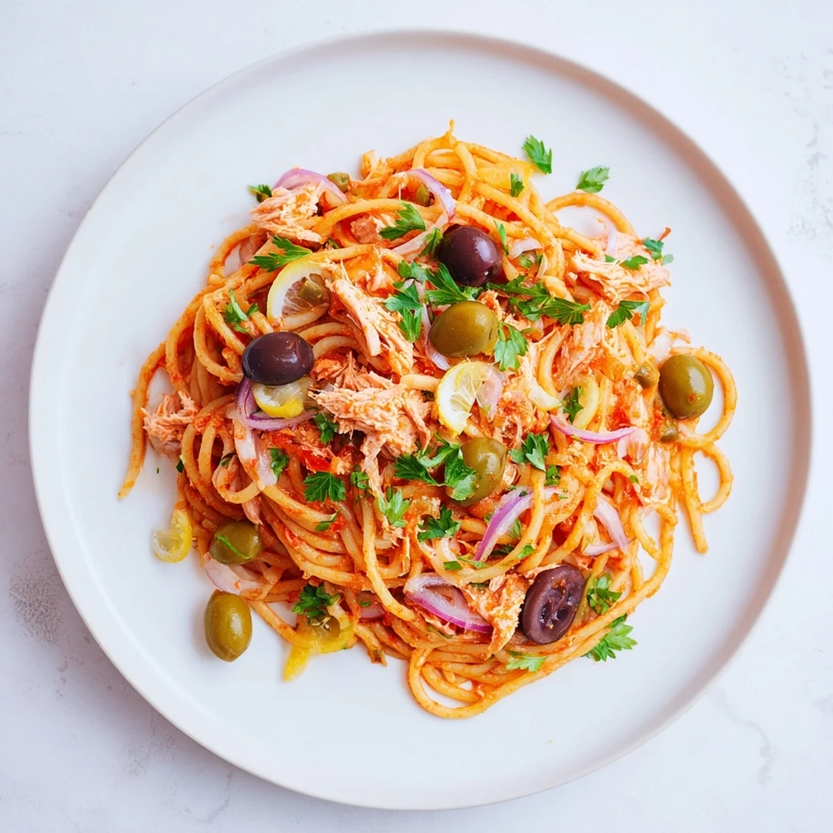 Close-up of a rustic pasta with tuna, olives & capers dish, ready for a delicious Italian meal.
