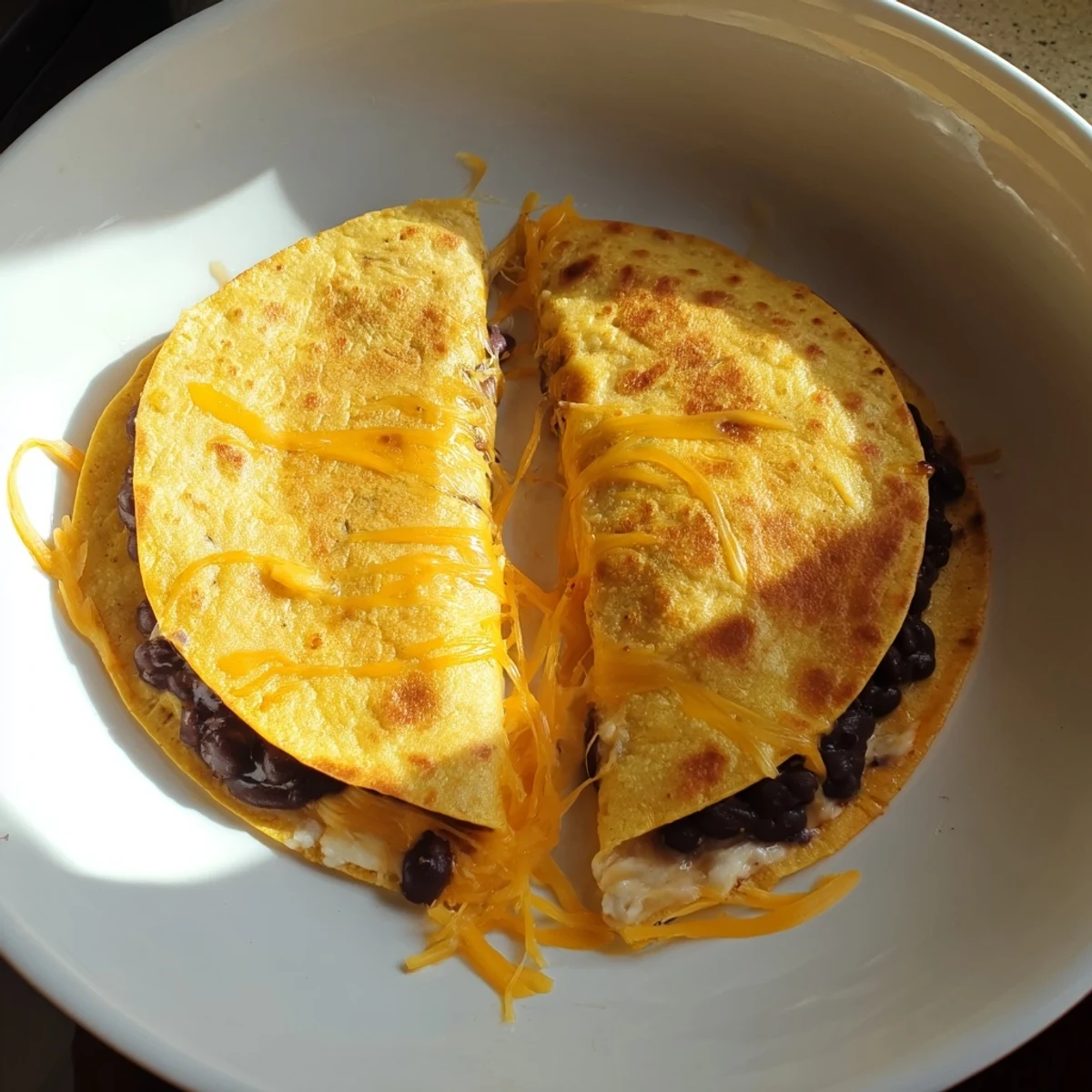A close-up of cheesy bean and cheese quesadillas, warm from the skillet with perfect texture ready to eat.