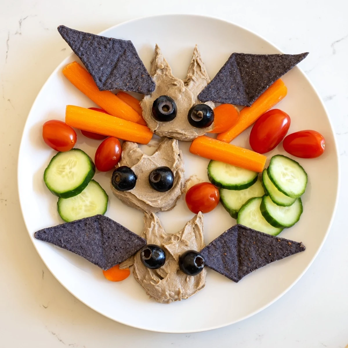 Vibrant Spooky Bat Bean Dip Platter, served with colorful veggies and crunchy tortilla chips, ready to enjoy.