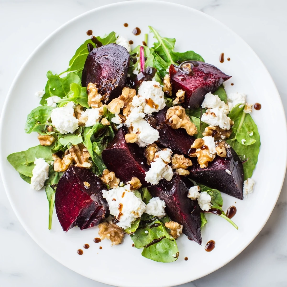 This Beet and Goat Cheese Salad displays the colorful contrast of beets with tangy goat cheese, drizzled in balsamic.