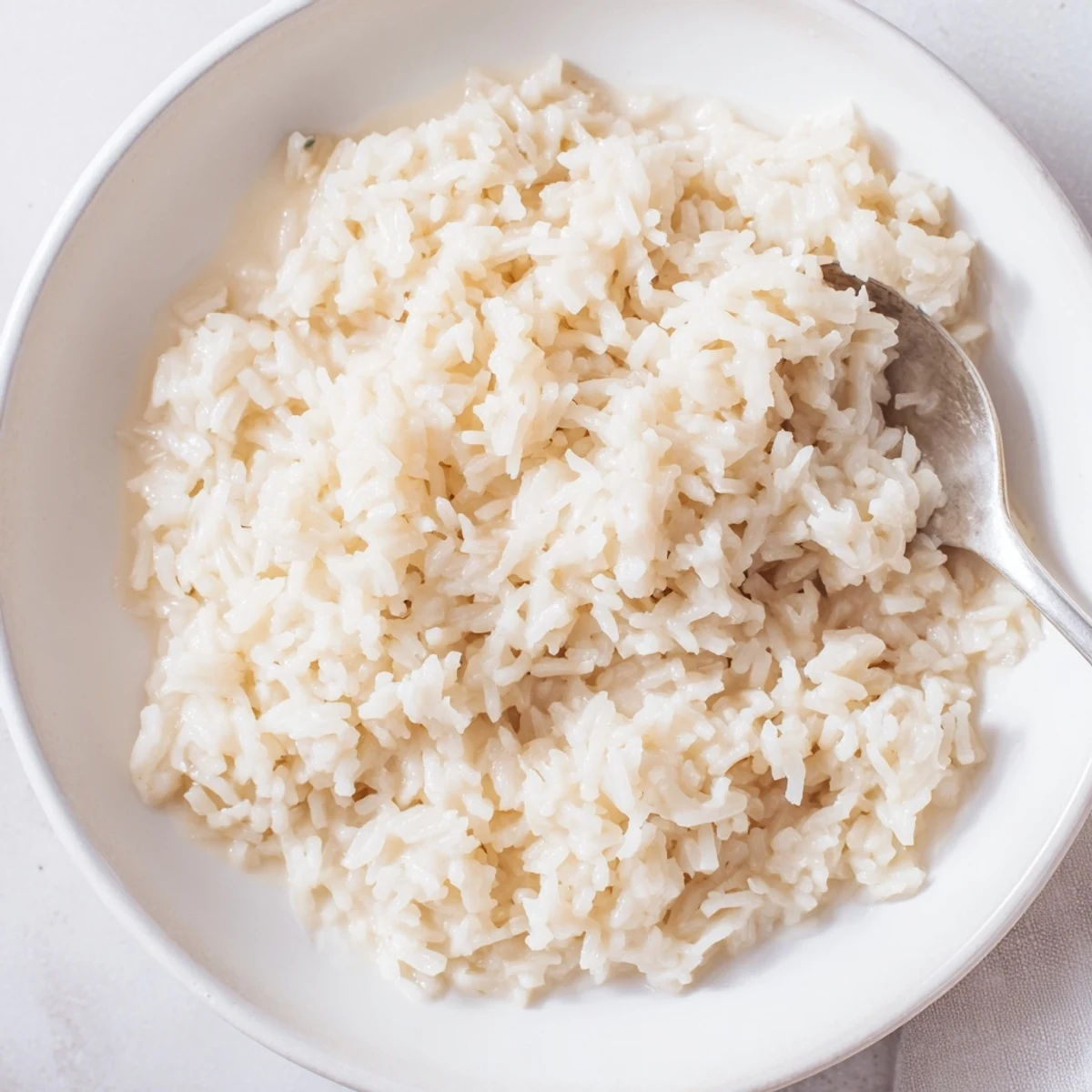 Fluffy, creamy coconut jasmine rice glistens, ready to serve alongside a vibrant Thai curry tonight.