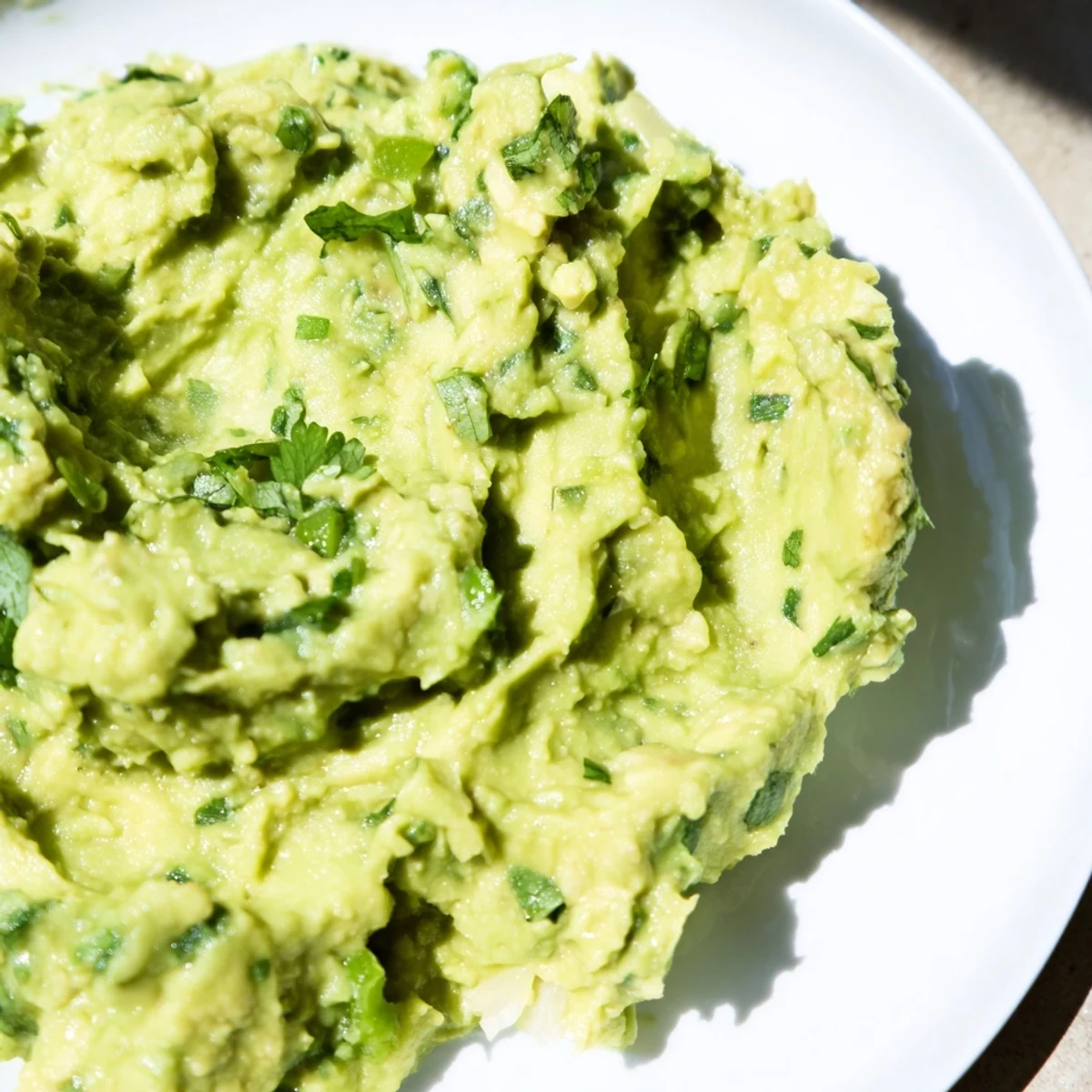 Freshly made avocado lime dip, a bright green appetizer, boasting the taste of lime and cilantro.