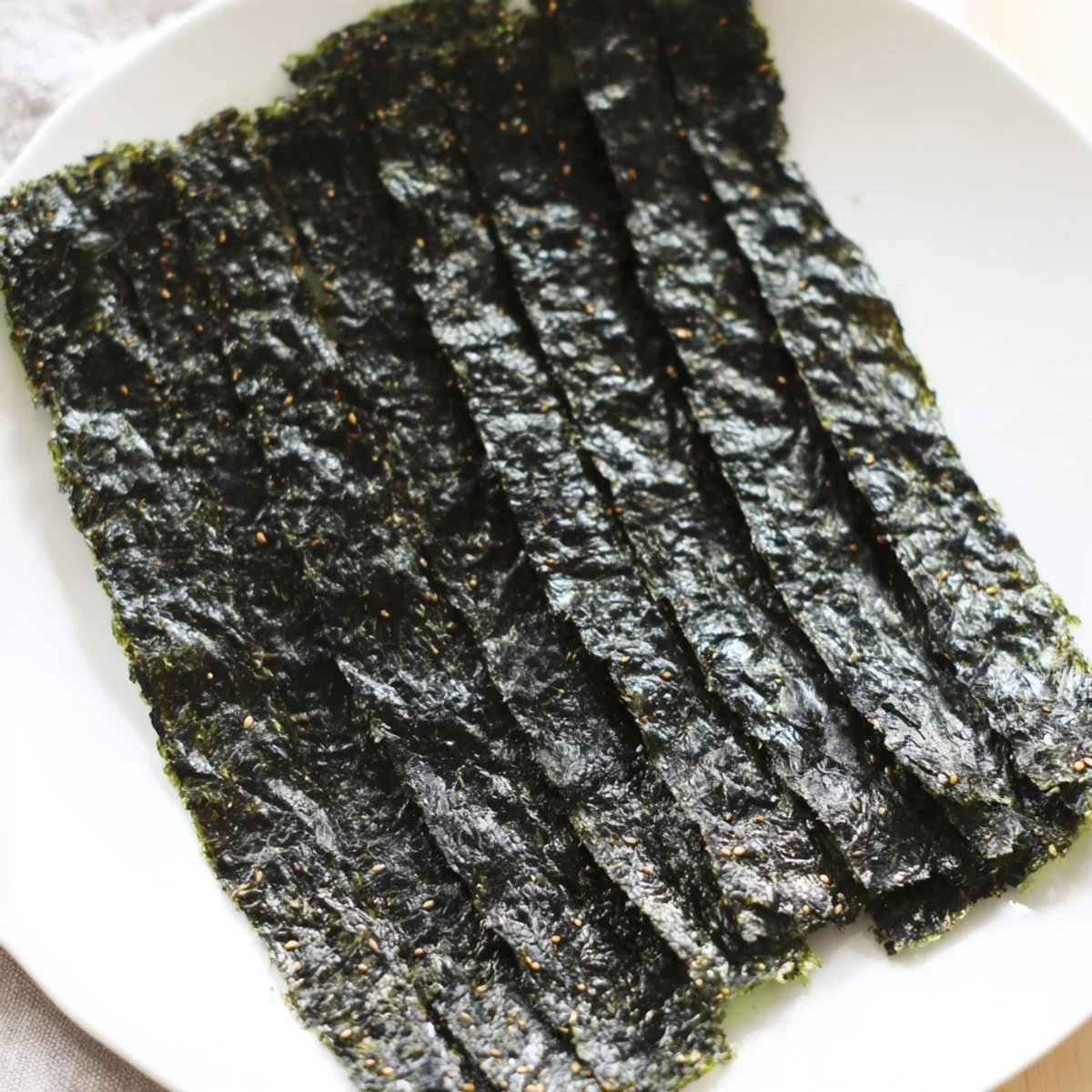 Golden, crispy Roasted Seaweed Chips, visibly dark green, seasoned with sesame oil and sea salt before baking.