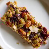 Close-up of chewy, homemade Roasted Pumpkin Seed & Cranberry Granola Bars, a healthy snack option.