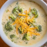 Rich and creamy Broccoli Cheese Soup, garnished and ready to serve with crusty bread.