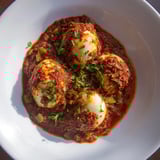 Get ready for a flavorful bite; this Shakshuka features perfectly cooked eggs in a rich, spiced tomato base.