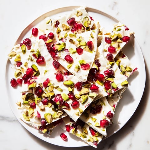 Frozen yogurt bark, bursting with jewel-toned pomegranate and crunchy pistachios in a frozen treat.