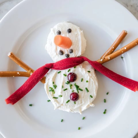 A whimsical Melted Snowman Dip, creamy and delicious, ready to scoop with crackers.