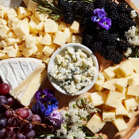 Enchanted Forest Grazing Board overflowing with colorful fruits, cheeses, and charcuterie, ready to devour.