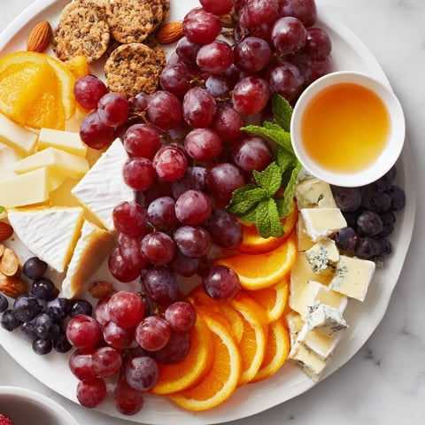 A beautifully arranged Grapes of Fortune dessert board with colorful grapes and cheeses.