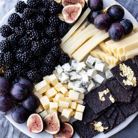 Deep Indigo Midnight Sky cheese board with blackberries, figs, and creamy cheeses mimicking stars.