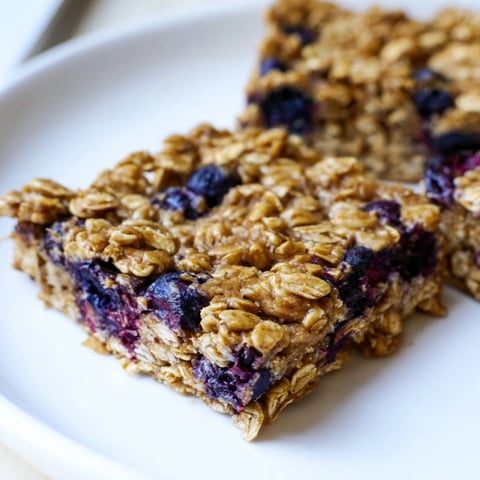 Golden-baked Blueberry Banana Oatmeal Protein Bars, studded with juicy blueberries, ready for a healthy breakfast.