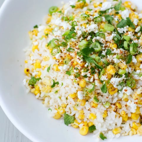 Fluffy Mexican Street Corn Rice, garnished with fresh cilantro and creamy cotija cheese, ready to be served.