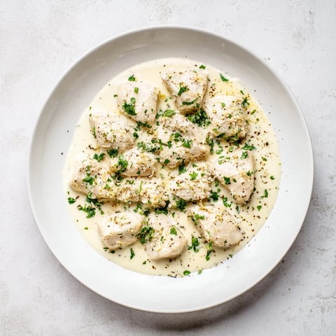 Golden-brown Creamy Garlic Chicken Bites simmering in a rich, Parmesan-infused sauce, garnished with fresh parsley.