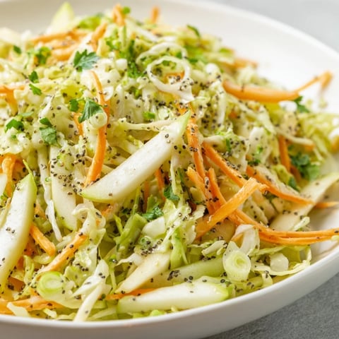 Green Cabbage and Apple Slaw served in a rustic bowl with a fresh parsley garnish.