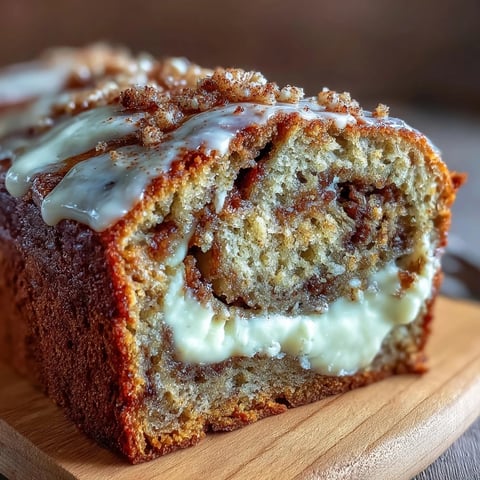 Cream Cheese Cinnamon Swirl Banana Bread sliced, revealing moist crumb and creamy filling, served on a white plate.