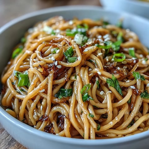Aromatic Asian ginger scallion noodles tossed in a savory soy glaze with fresh herbs and sesame seeds.  