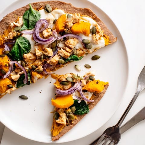 Golden Protein Pumpkin Ricotta Pizza with vibrant spinach, ready to slice and serve.
