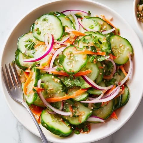 Vibrant cucumber salad remix adorned with fresh cilantro, ideal as a light appetizer.  