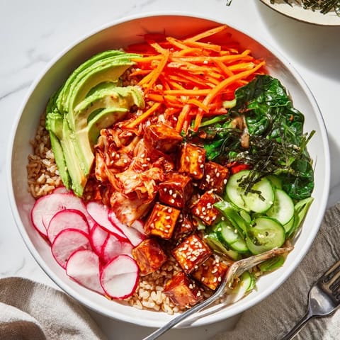 Vibrant fermented vegetable bowl topped with kimchi, creamy avocado, and grains.  