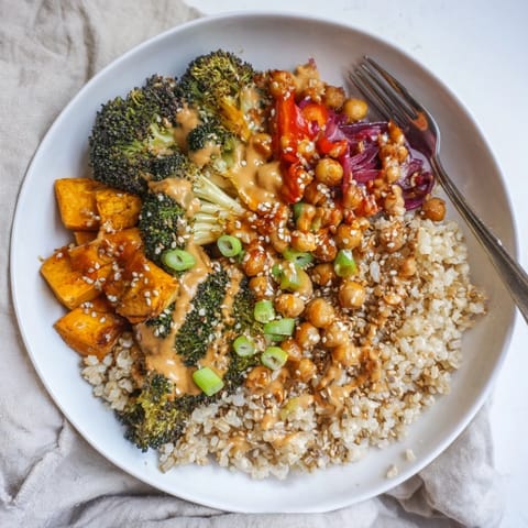 Colorful grain bowls showcasing roasted sweet potatoes and gochujang-maple sauce drizzled atop.  