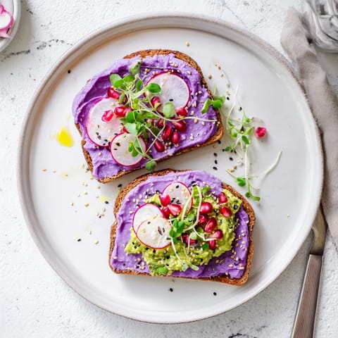 Colorful breakfast toasts featuring creamy avocado and tangy pomegranate seeds on top.  