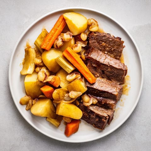 Steaming plate of Sunday Pot Roast, showcasing juicy beef, vibrant carrots, and savory pan juices.