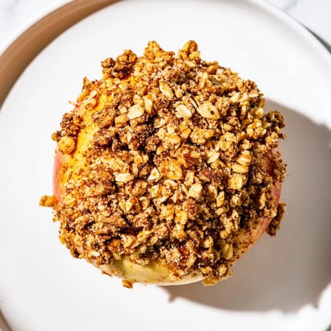 Warm, spiced baked apples with oat-nut crumble, showing a perfect, tender dessert ready to enjoy.