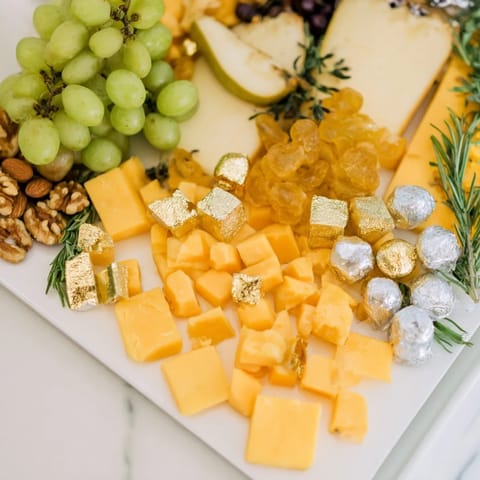 A close-up of a beautifully arranged Gold and Silver Cheese Cube Board, featuring vibrant ingredients and crackers.