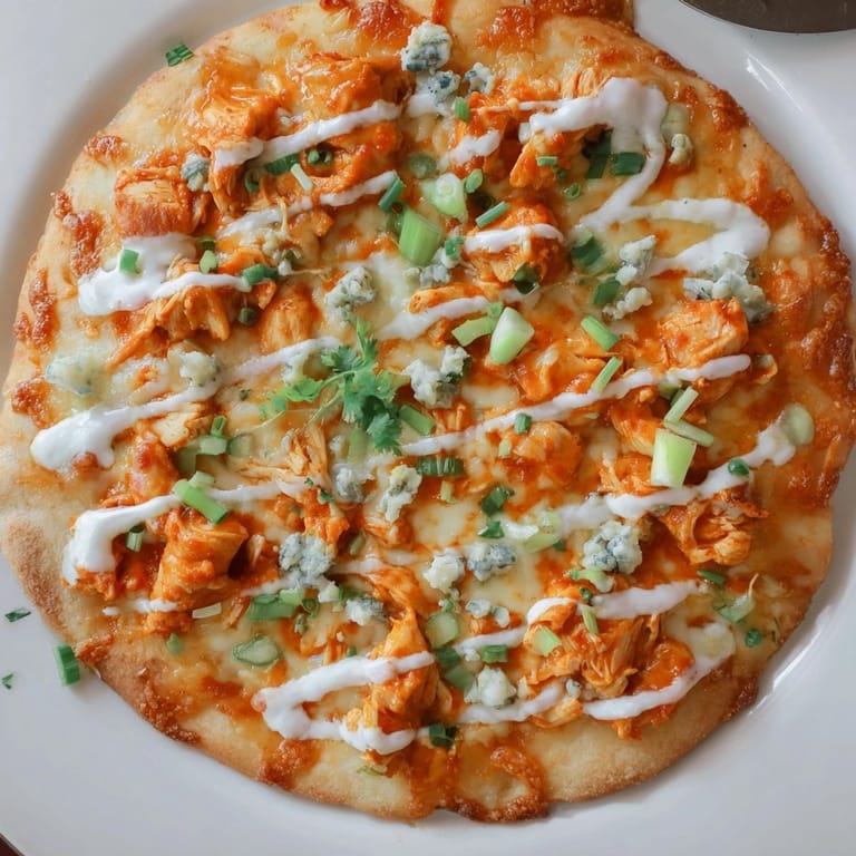 Homemade Buffalo Chicken Pizza: spicy buffalo sauce, tender chicken, and creamy dressing details.