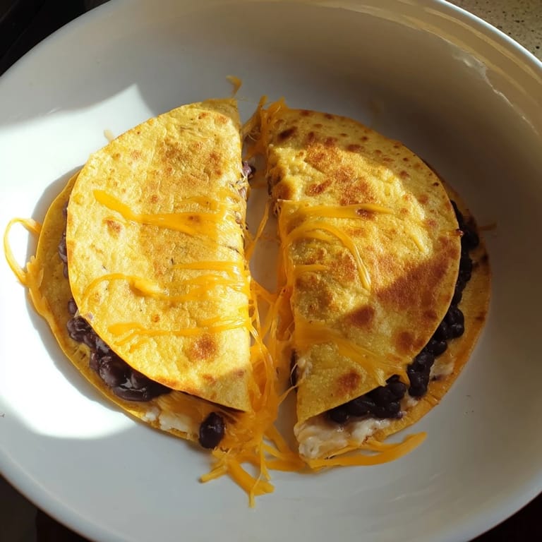 A close-up of cheesy bean and cheese quesadillas, warm from the skillet with perfect texture ready to eat.