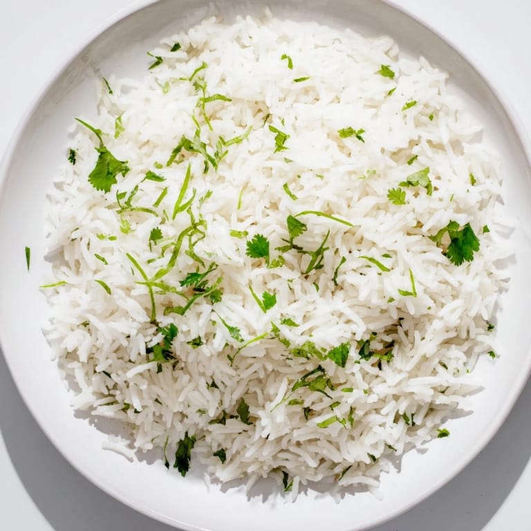 Steaming bowl of delicious cilantro lime rice, with lime wedges and vibrant cilantro.