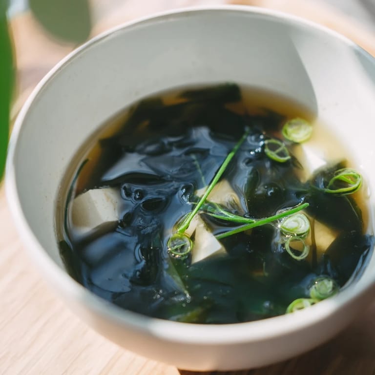 Savor a light, aromatic serving of Wakame Soup, rich with umami dashi, soft tofu, and rehydrated seaweed, perfect as a starter.