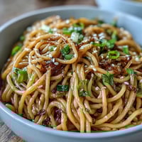 Aromatic Asian ginger scallion noodles tossed in a savory soy glaze with fresh herbs and sesame seeds.  