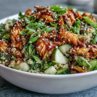 Golden toasted sesame seeds glisten on Asian Sesame Chicken Couscous Salad with cucumbers and scallions. 